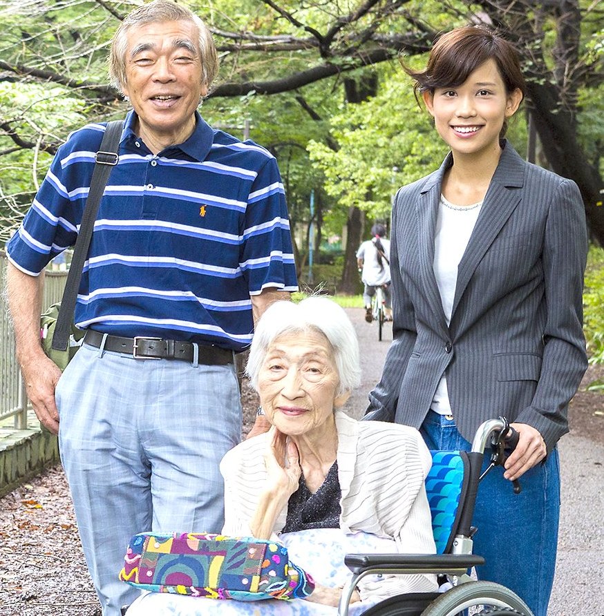 公園を散策する車いすのお客様とご家族、トラベルヘルパー